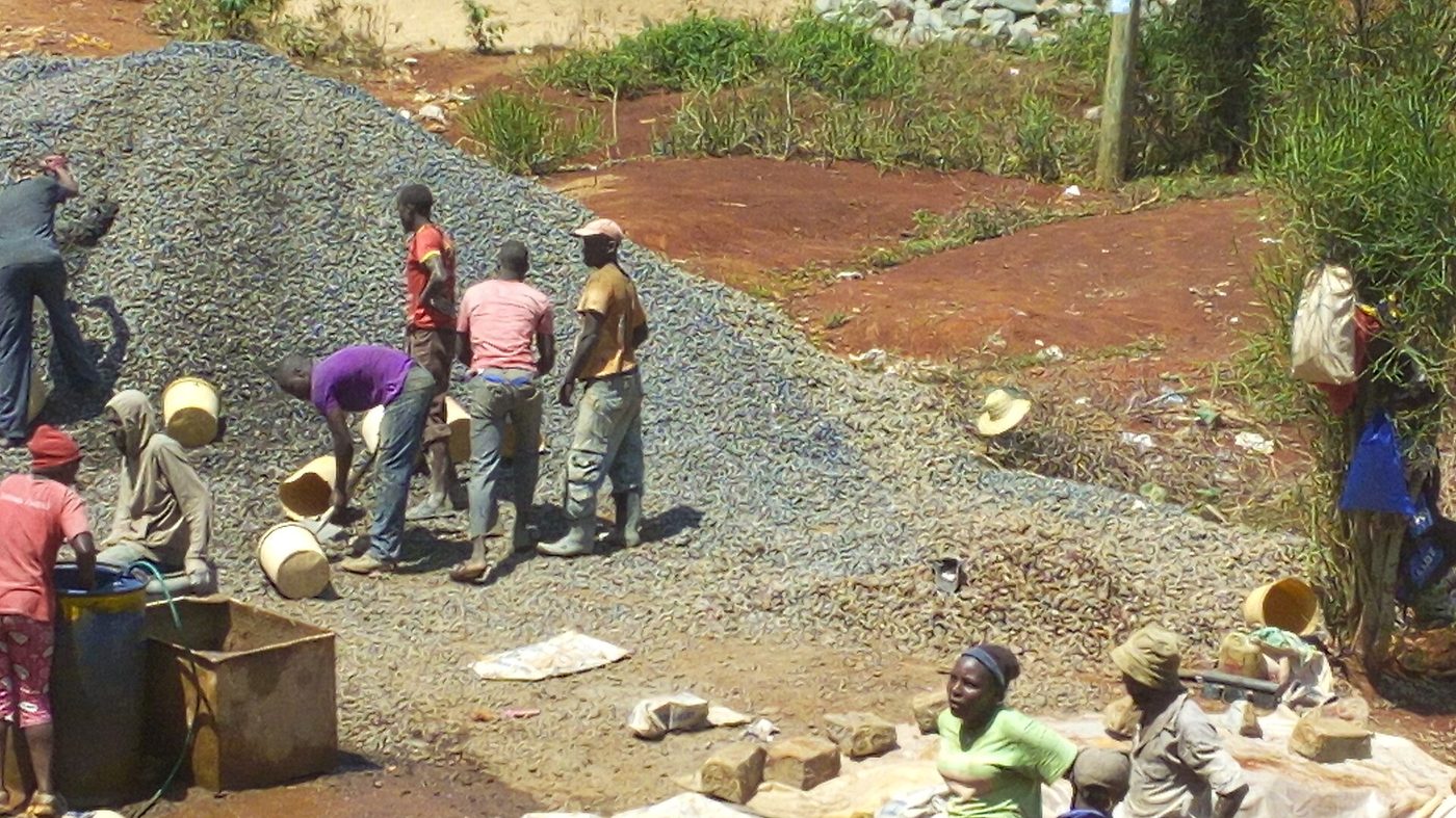 Site workers batching concrete materials by hand in Embu, Kenya
