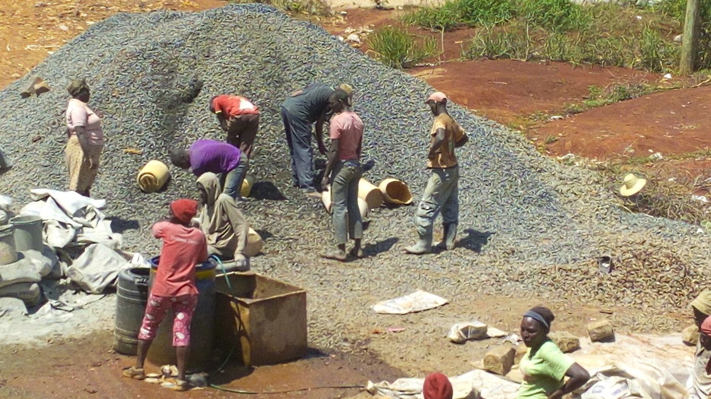 Workers adding water to a concrete mix on a site in Embu, Kenya